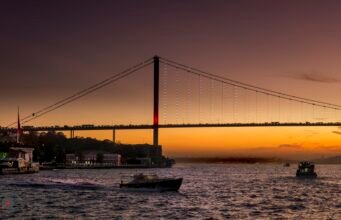 Bosphorus Yacht Proposal in Istanbul: How to Plan It The Bosphorus Bridge silhouetted against an orange sunset over the water, Istanbul