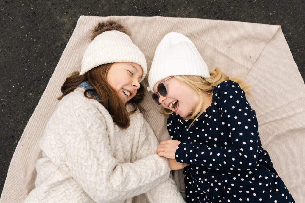 Two sisters laughing during a Prague family photoshoot