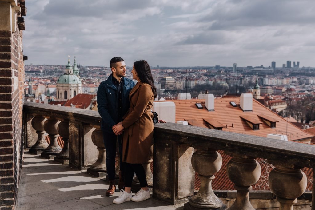 Engagement couple on a balcony above Prague